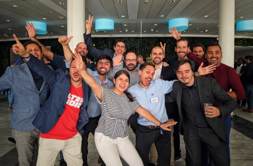 Grupo de personas celebrando en un evento, con sonrisas y manos en alto, simbolizando resultados medibles.